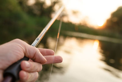 Close-up of hand holding fishing rod