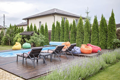 Chairs and table by trees against sky