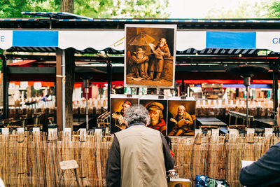 Rear view of men at market stall