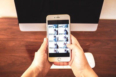 Low section of person using smart phone on table