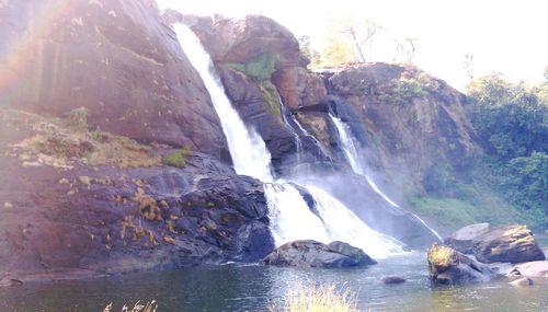 Scenic view of waterfall against sky