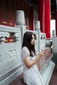 Side view of woman looking at camera