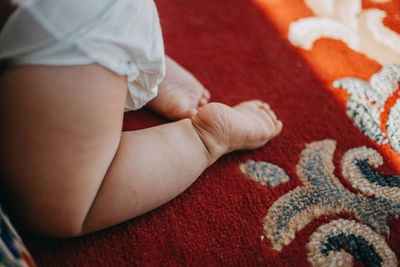 Low section of baby kneeling on bed