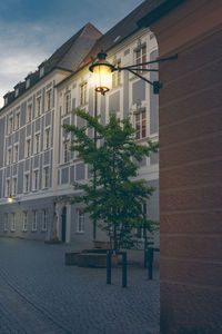 Street by buildings against sky at dusk