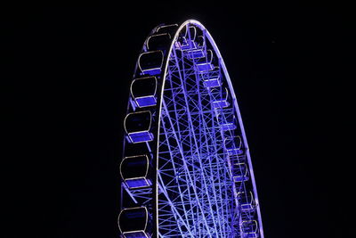 Low angle view of illuminated ferris wheel against sky at night