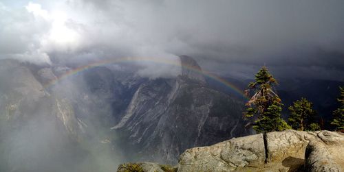 Scenic view of rainbow over mountains against sky