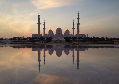 Reflection of building on water at sunset