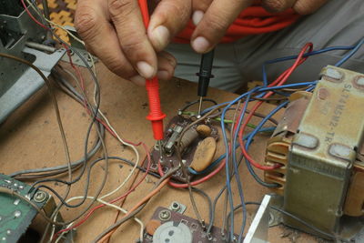 Cropped hands of male technician repairing radio