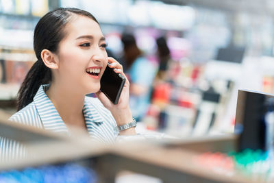 Young woman looking away while using mobile phone