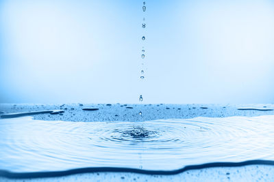 Close-up of splashing water against blue background