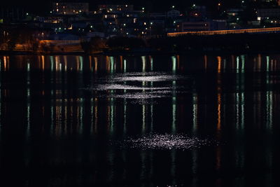 Reflection of illuminated water in sky at night