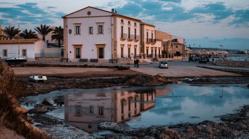 Houses by water against sky