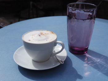 Coffee cup and drinking glass on table