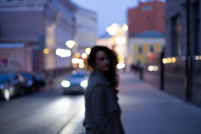 Woman young standing on city street at night
