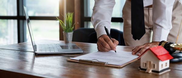 Midsection of businessman working on table