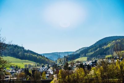 Scenic view of townscape and mountains against sky