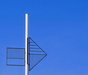 Low angle view of pole against building against clear blue sky
