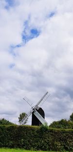Traditional windmill on field against sky