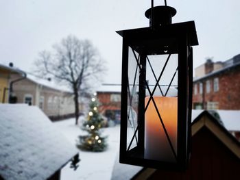 Close-up of electric lamp on house during winter