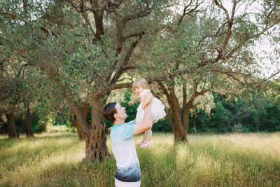 Rear view of women standing by tree