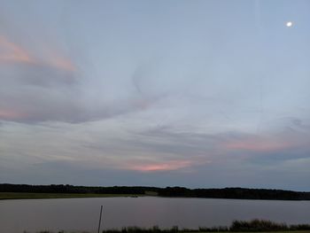 Scenic view of lake against sky at sunset