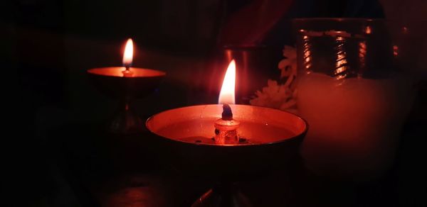 Close-up of lit diyas in darkroom