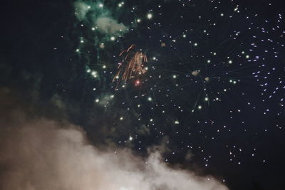 Low angle view of firework display at night