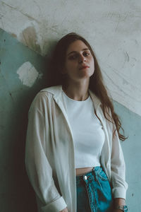 Portrait of woman standing against wall