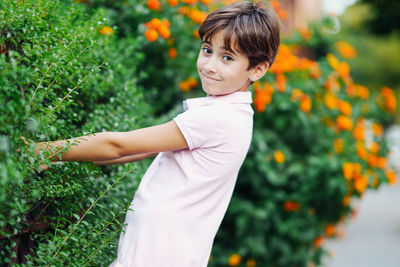 Portrait of girl standing by plants