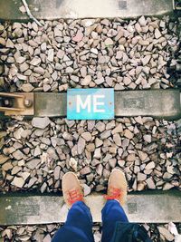 Low section of person standing on railroad track