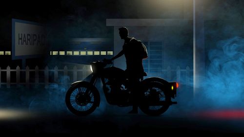 Side view of silhouette man riding motorcycle at night