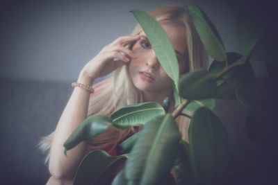 Close-up of young woman by plant