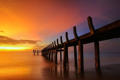 Pier on sea at sunset