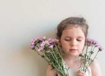 Portrait of cute girl holding flowering plant