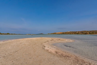 Scenic view of beach against blue sky