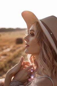 Close-up of young woman wearing hat against sky