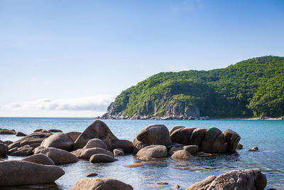 Rocks by sea against sky