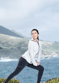 Young woman exercising by sea