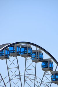 Low angle view of ferris wheel against clear blue sky