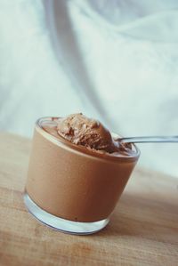 Close-up of chocolate mousse served in glass on wooden table