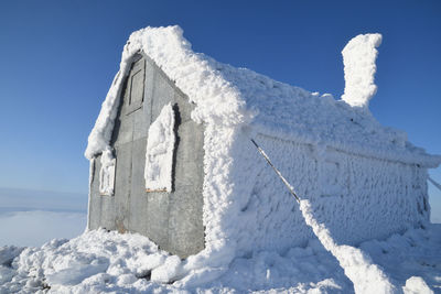 Low angle view of snow covered blue sky