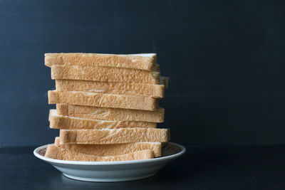 Close-up of stack of food on table against black background