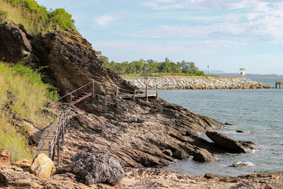 Rock formation on beach against sky