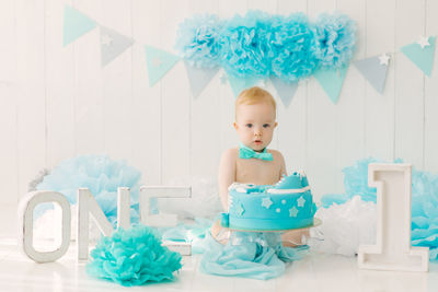 Birthday party for  boy in blue and turquoise garlands and a cake, holiday concept and decor