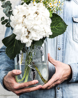 Midsection of man holding flower