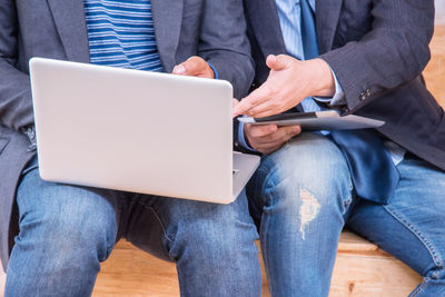 Low section of man using laptop