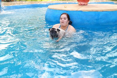 Woman with dog swimming in pool