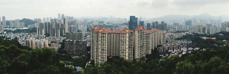 Aerial view of cityscape against cloudy sky