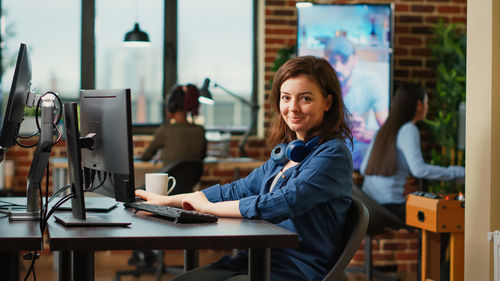 Young woman using laptop at cafe