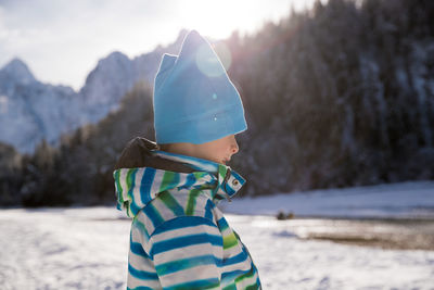 Boy with umbrella on snow covered land